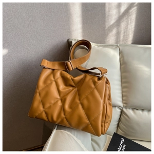 Detailed view of caramel brown quilted crossbody bag with golden metal adjustment buckle