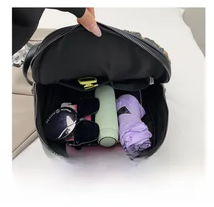 Top view of spacious interior of black PU leather backpack with various travel essentials