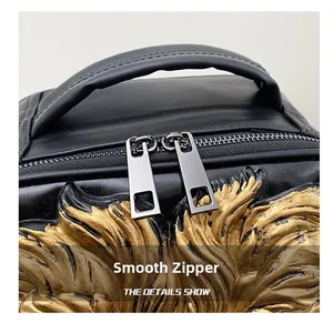 Close-up of smooth double metal zippers on black leather bag with golden feather emblem