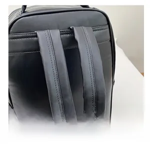 Detail showing the wide ergonomic black faux leather shoulder strap of the backpack