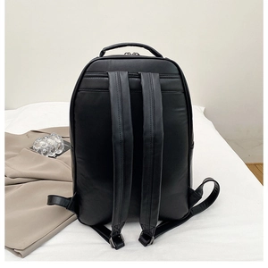 Detail view of the ergonomic padded straps and reinforced handle of this black leather backpack