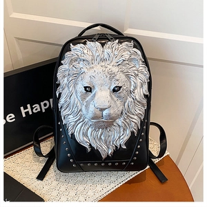 Detail of a black leather backpack featuring a 3D silver lion head relief and metal studs