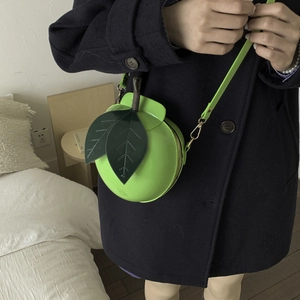 Vibrant green apple-shaped crossbody bag with leaf handles and adjustable strap