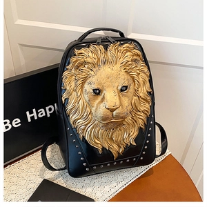 Detail of black leather backpack featuring 3D gold lion head and silver rivets decoration