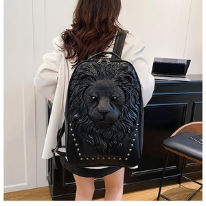 Close-up of 3D lion head relief and silver studs on black leather commuter backpack