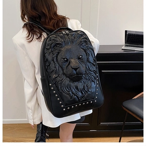 Detail of creative 3D lion head embossing and silver rivets on a black leather backpack