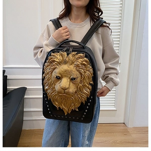 Detail of 3D gold lion head relief and silver studs on black leather backpack