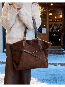 Détail du sac cabas en peluche marron avec lanières en cuir et boucles métalliques hiver