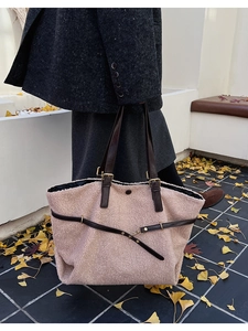 Dettaglio borsa tote in pile rosa con manici in pelle marrone scuro e fibbie dorate
