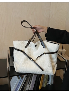 Détail du cabas blanc en fausse fourrure avec anses en cuir marron et boucles dorées