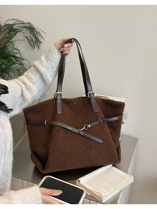 Détail du sac fourre-tout en peluche marron avec sangles en cuir et boucles dorées