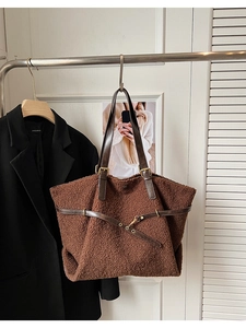 Détail du sac cabas en peluche marron avec lanières en cuir et boucles dorées sur cintre