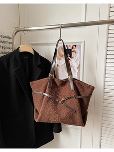 Détail d'un sac cabas en peluche marron avec anses en cuir et boucle en métal doré
