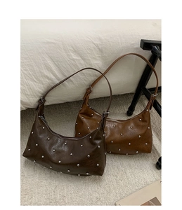 Detail view of retro hobo underarm bags with metallic silver studs and zip closure