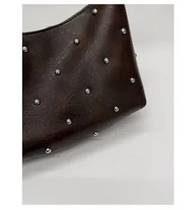 Close-up of vintage dark brown faux leather texture with metallic silver rivet details
