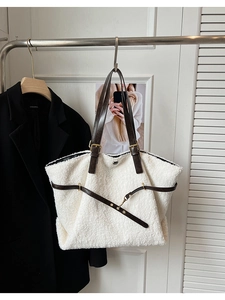 Détail du sac fourre-tout en peluche blanche avec anses en cuir brun et anneaux dorés