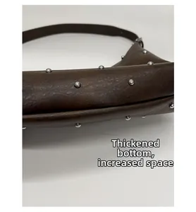 Detail of brown leather bag showing reinforced thick bottom and silver rivet studs