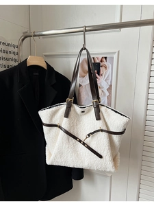 Détail du grand sac cabas en moumoute blanche avec des anses en cuir marron foncé