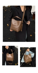 Close-up of brown crocodile embossed bucket bag with adjustable shoulder strap and handle