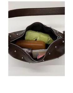 Top view of spacious interior of brown rivet shoulder bag with daily essentials inside
