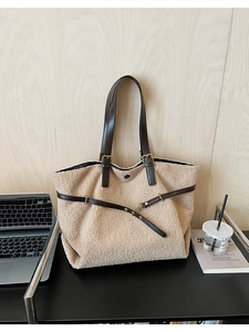 Détail du cabas en polaire beige avec lanières en cuir marron et boucles dorées