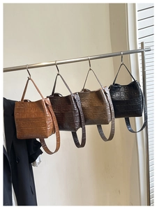 Hanging display of crocodile pattern bucket bags in four colors with slim shoulder straps