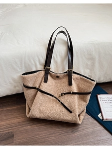 Détail d'un sac cabas en peluche beige avec lanières en cuir et boucle décorative