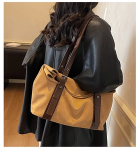 Detail of camel tote bag with brown leather straps shown on model for capacity view