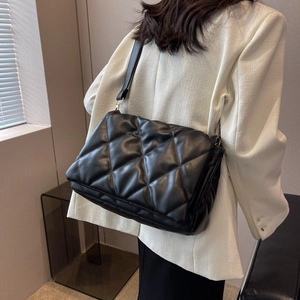 Classic black quilted shoulder bag with large diamond stitching and adjustable strap
