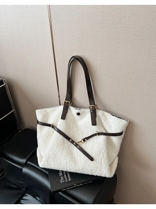 Détail du sac cabas en polaire blanche avec lanières en cuir marron et boucles dorées