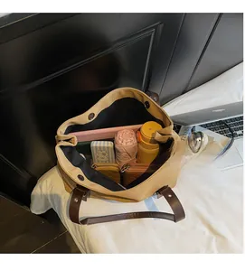 Large khaki tote bag interior showing capacity for umbrella, wallet, and tablet