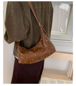 Detail view of coffee leather hobo bag with silver studs and adjustable strap