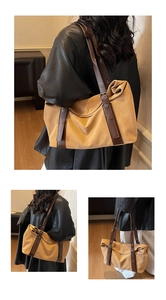 Detail of adjustable leather strap and textured fabric on khaki oversized tote bag