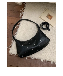 Detail of black leather hobo bag with silver studs and adjustable shoulder straps