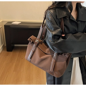 Detail of vintage brown canvas tote bag with adjustable leather straps and silver buckles