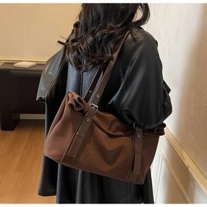 Detail view of large brown commuter tote bag with adjustable leather strap on model