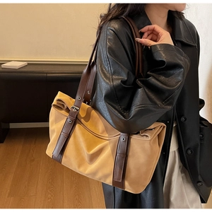 Detail of adjustable leather strap and metal buckle on the large contrast color tote bag