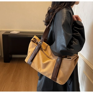 Detail of ginger canvas tote bag with adjustable brown leather strap and metal buckle
