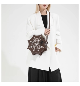 Brown spider web shaped shoulder bag shown on model with creative holiday theme