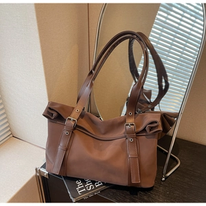 Detail of coffee brown tote bag showing adjustable leather strap and nylon texture