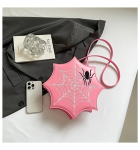 Detailed top view of pink spider web shaped crossbody bag with black spider patch detail