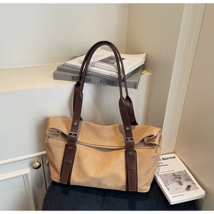 Detail of vintage tote bag with metal buckles and soft apricot suede texture