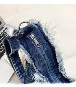 Macro shot of silver metal zipper and frayed denim fringe on a blue butterfly backpack