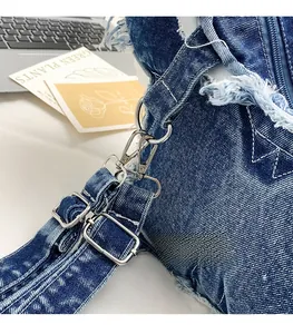 Macro detail of adjustable denim strap with silver metal buckle on a vintage backpack