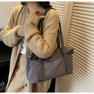 Detail of dark grey tote bag with unique rolled edge closure and metallic eyelets
