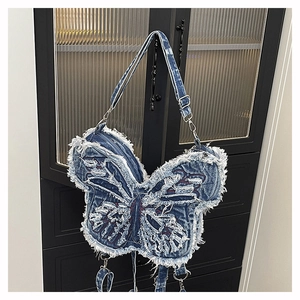 Close-up of distressed butterfly denim bag showing frayed edges and textured wash detail