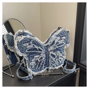 Close-up of butterfly denim bag featuring distressed frayed edges and washed blue texture