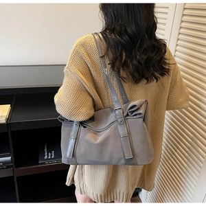 Detail of grey shoulder bag with bow knot pleats and adjustable buckle strap