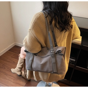 Detail of a large winter tote bag showing adjustable belt buckle and soft texture