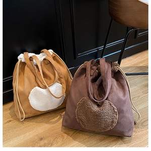 Detail showing two plush heart patchwork drawstring bucket bags in brown and dark coffee